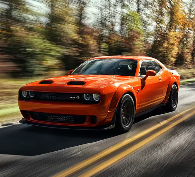 Orange Challenger driving on Road